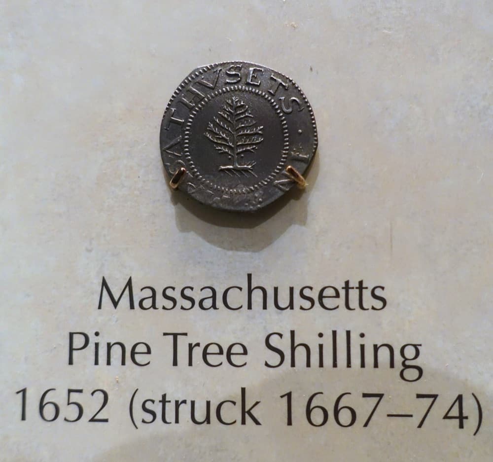 1652 Massachusetts Pine Tree shilling, obverse with pine tree, on the Smithsonian's exhibit mount labeled 'struck 1667-74' (the large-planchet period) — the Smithsonian's example of the same issue; the tracked PCGS MS65 specimen is a different coin